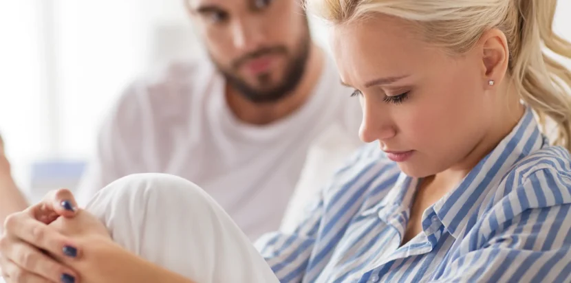 A couple consulting with a female doctor in a professional office, discussing ways to cope with infertility.