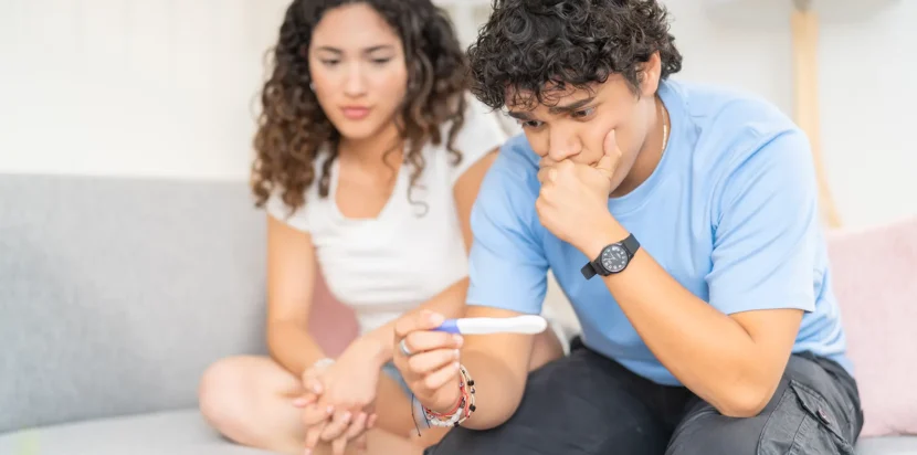 A couple consulting with a female doctor in a professional office, discussing the causes of infertility.