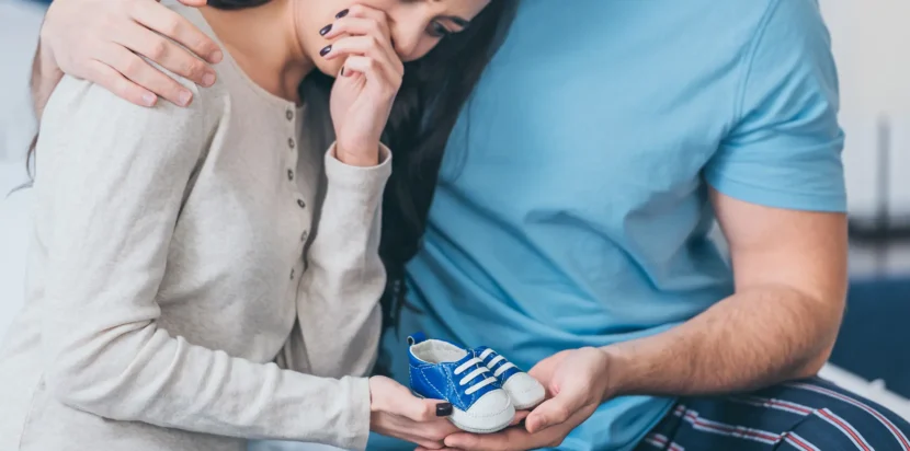 A couple consulting with a female doctor in a professional office, discussing infertility symptoms, causes, and treatment methods.